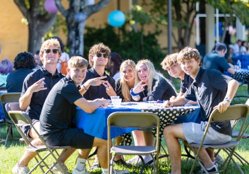 Students sitting at a table on the quad